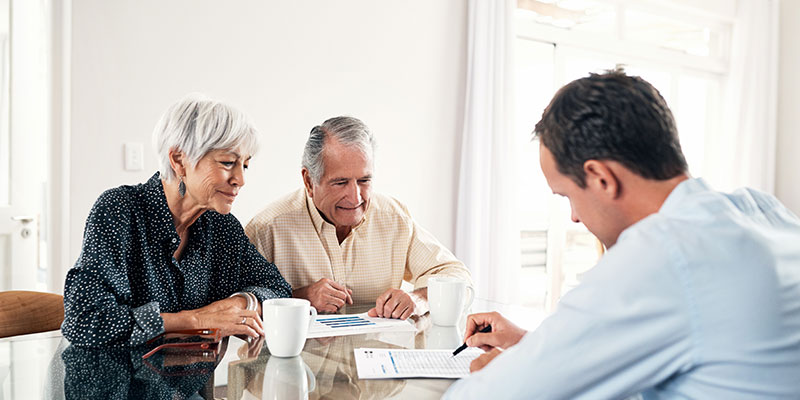 Older couple consulting with a professional at a table.