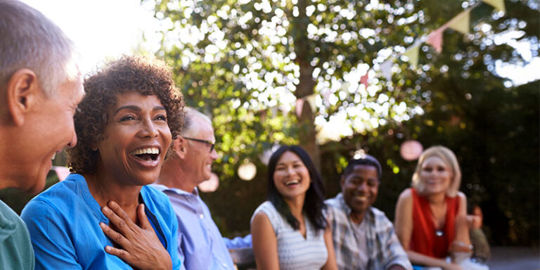 A group of friends sit outside talking and laughing