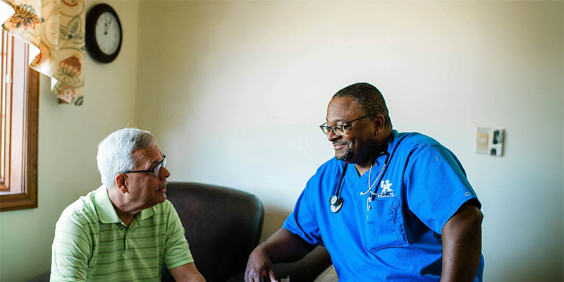 Doctor and patient engaged in friendly conversation indoors.
